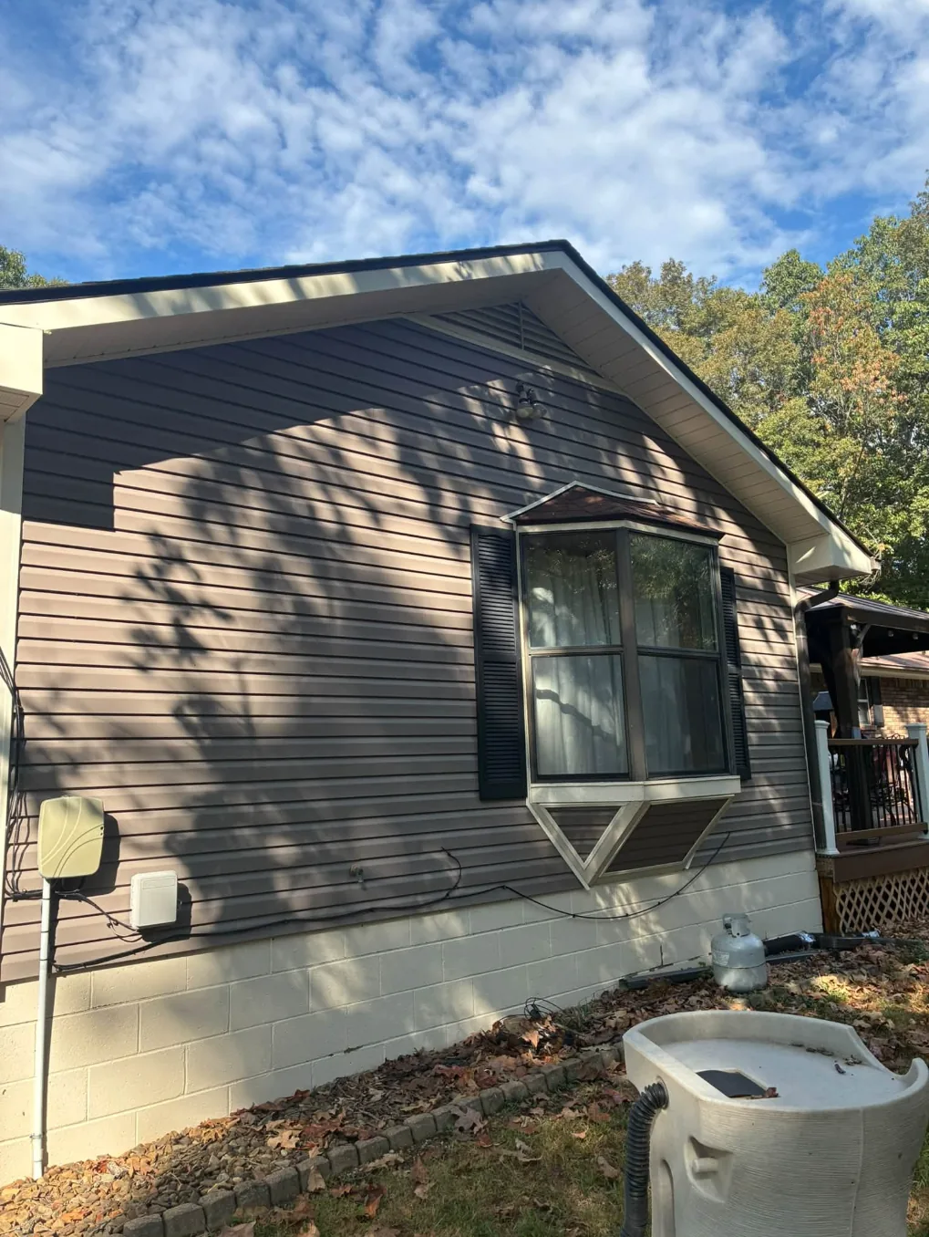 The same gray siding and bay window after washing