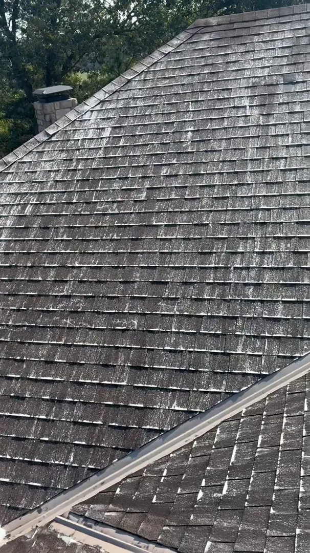 Streaked gray shingle roof being washed