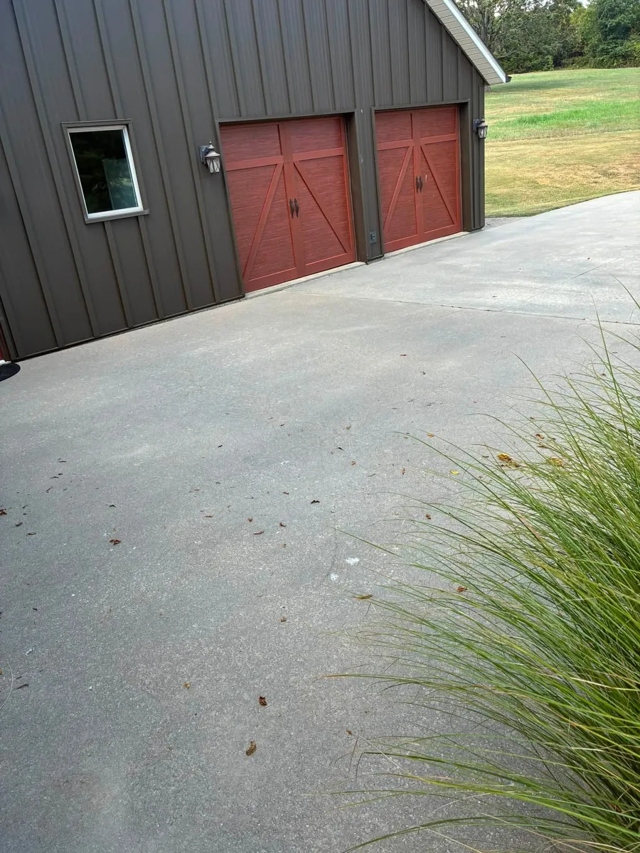 Dark metal building with two red carriage-style garage doors