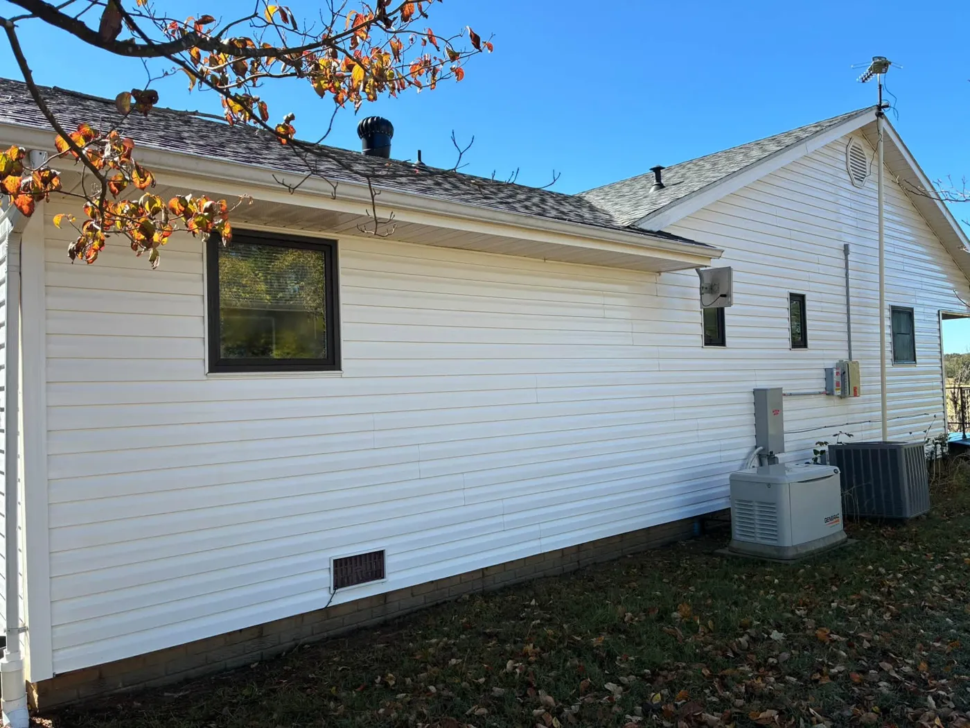 White sided house under a shingle roof, washed clean