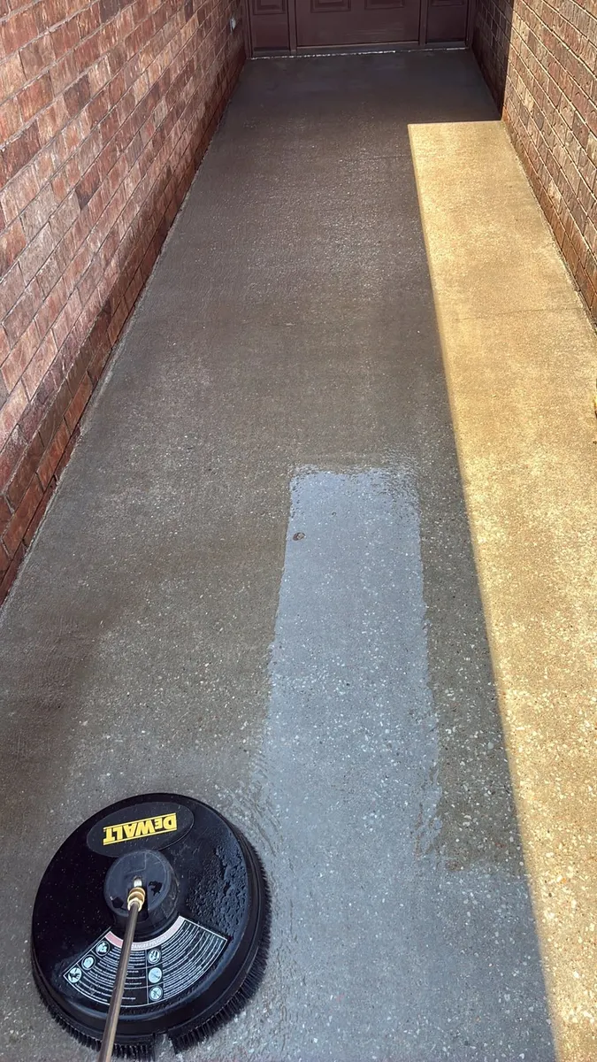 Surface cleaner on a brick-lined concrete walkway, leaving a clean stripe